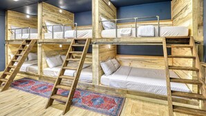 A multi-level bunk bed room with wooden walls and a blue accent wall. - Rainier Bunkhouse & Bar-Cade- HotTub,MtnView,2 blks to Packwood Brewing! Pets ok (Packwood)