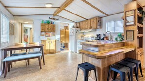 A spacious kitchen with wooden beams, a central island, and built-in bar stools. - Rainier Bunkhouse & Bar-Cade- HotTub,MtnView,2 blks to Packwood Brewing! Pets ok (Packwood)