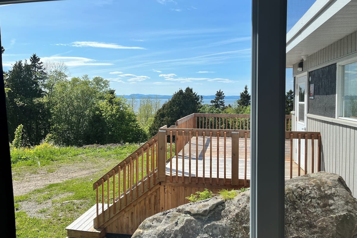A wooden deck with a view of a lake and mountains.