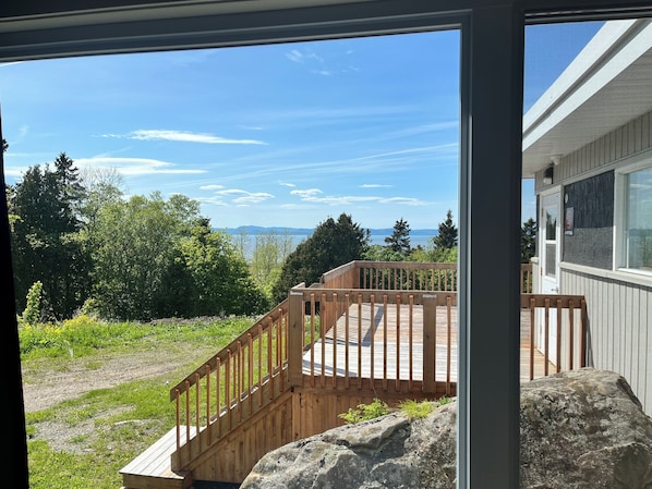 A wooden deck with a view of a lake and mountains.