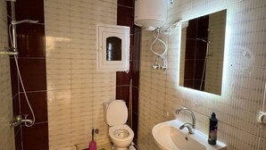 A bathroom with a checkered floor, a toilet, a sink, a bathtub, and a shower. - Spacious 2-Bedroom Apartment (Hurghada)