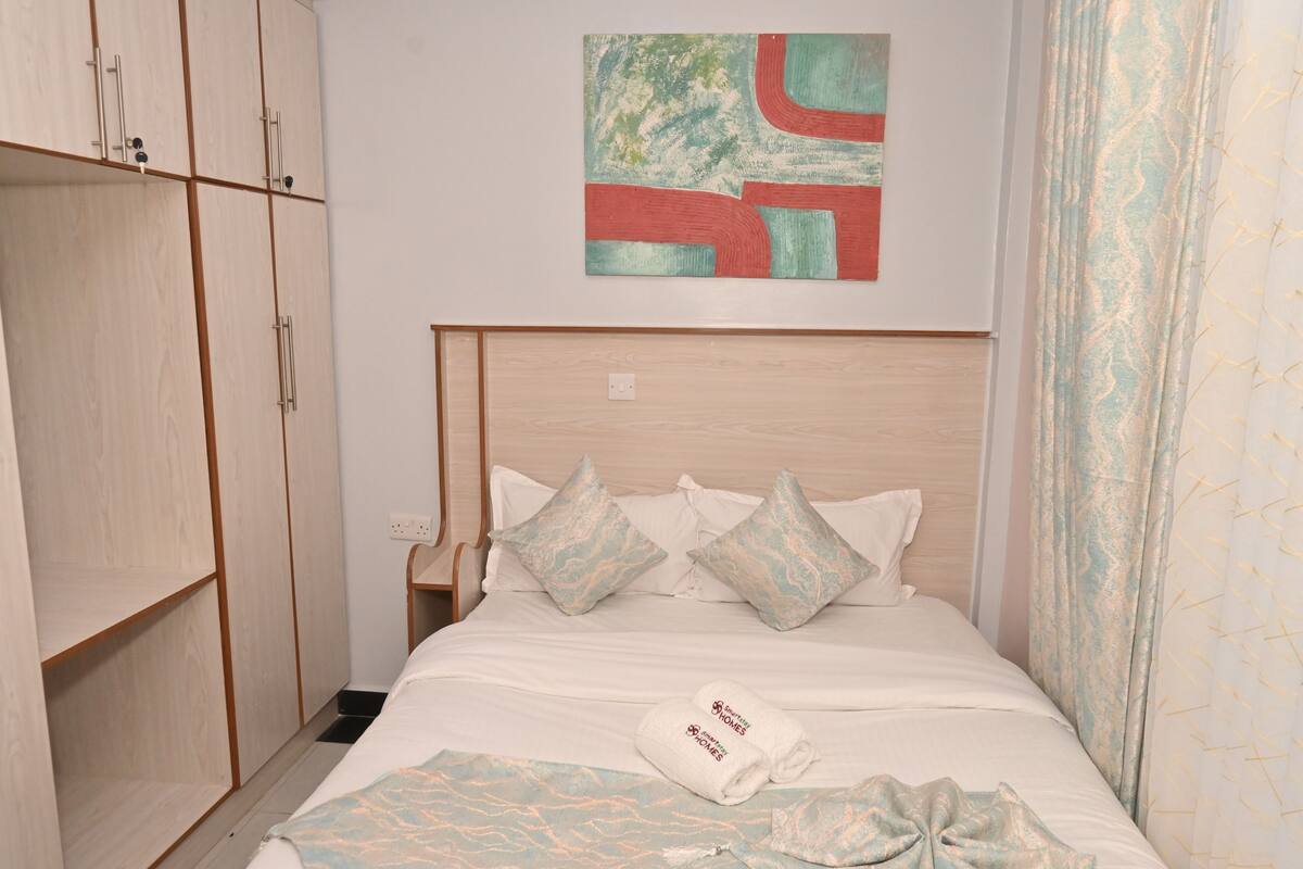 Ein Hotelzimmer mit Bett, Schrank und einem Gemälde an der Wand.