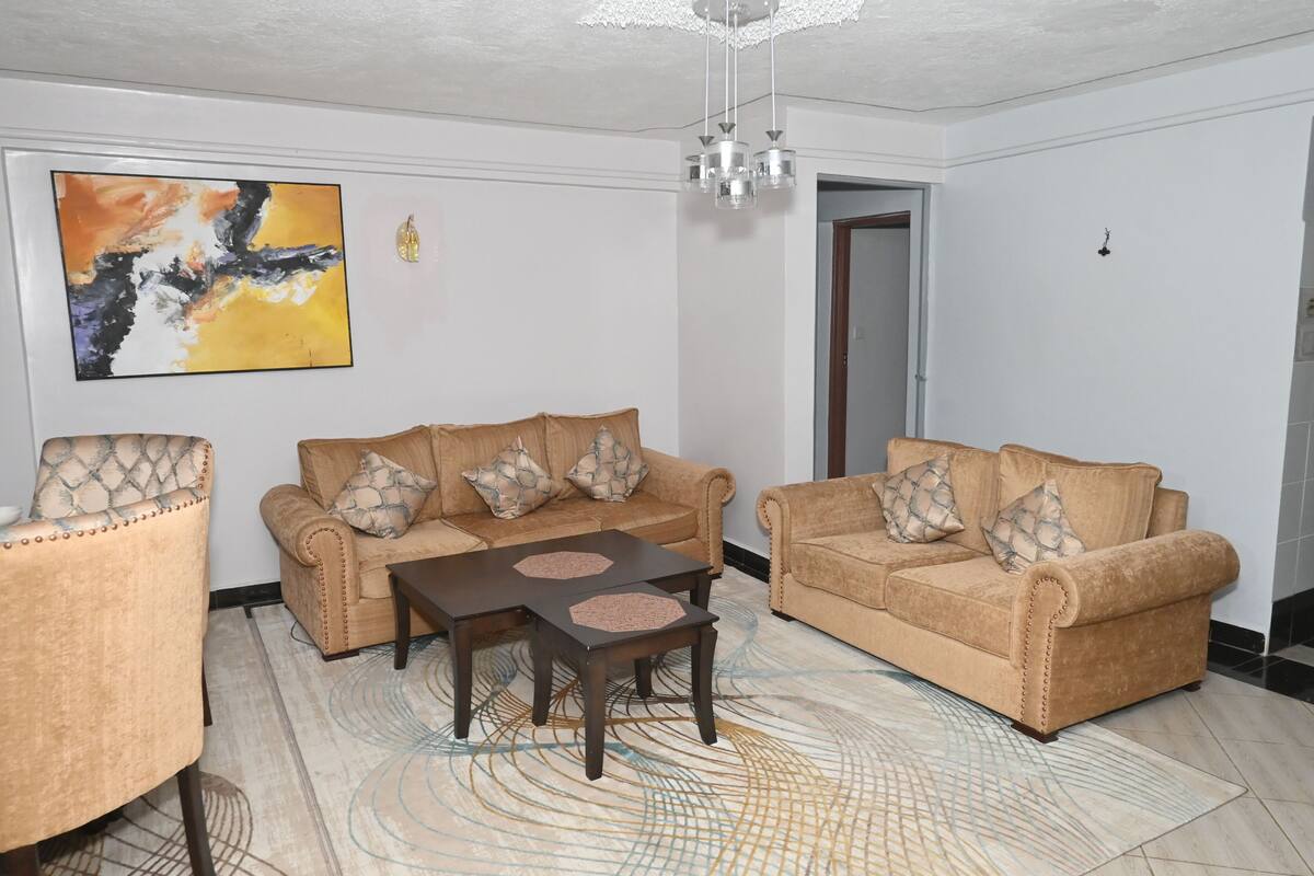 Ein Wohnzimmer mit zwei Sofas, einem Couchtisch und einem gemusterten Teppich.