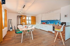 A modern kitchen with white cabinets, a wooden countertop, and a built-in oven.