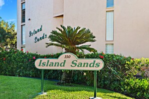 Une enseigne indiquant « Island Sands », avec le chiffre « 150 » et un palmier au premier plan.