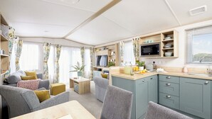 Um espaço compacto com área de refeições, cozinha compacta e disposição de assentos.