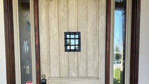 A wooden double door with a small window and a keypad lock.