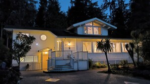 A two-story house with a porch, a staircase, and a driveway.