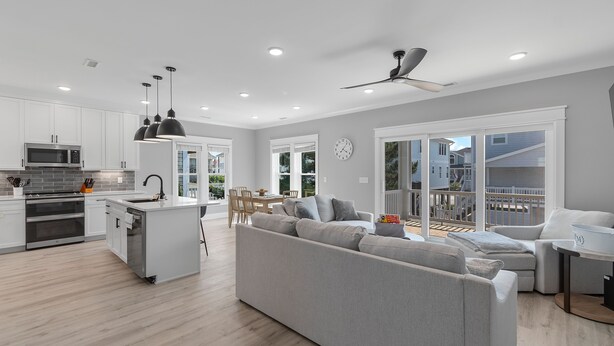Una cocina moderna con armarios blancos, microondas integrado y una isla central.