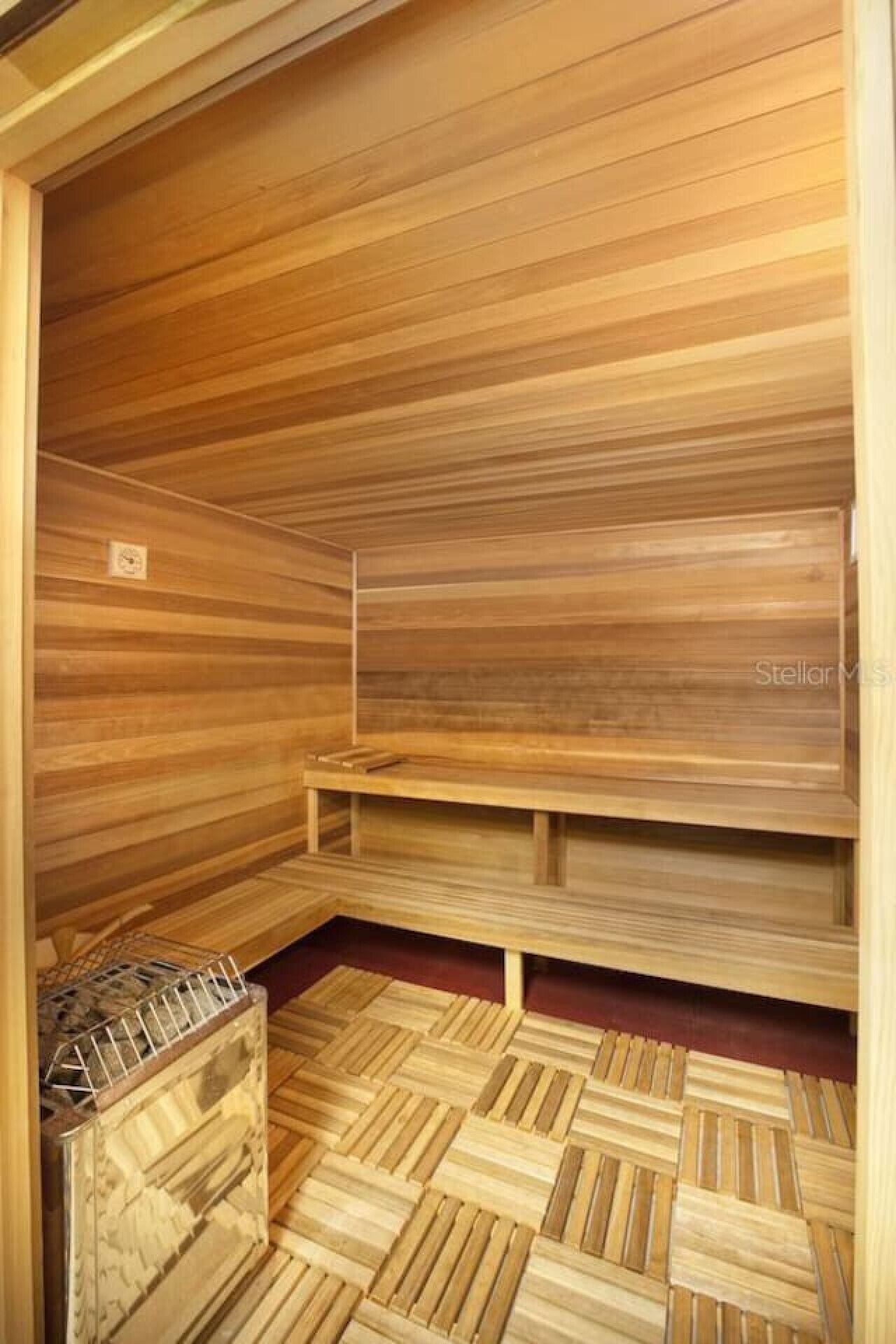Un sauna avec des bancs en bois et un sol carrelé.