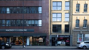 A building with a storefront labeled "MACROFOODCENTRE" and another store named "Silhani Beauty". - Bright Aldgate 1BR, close to Train & Liverpool Street, by Blueground (London)