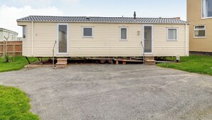 A mobile home with a front door, two windows, and a small porch area. - Castaways Oyster 10 (Pet) (Bacton-on-Sea)