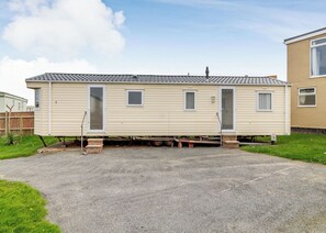 A mobile home with a front door, two windows, and a small porch area. - Castaways Oyster 10 (Pet) (Bacton-on-Sea)