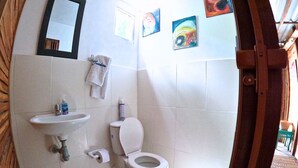 A bathroom with a sink, toilet, and a towel hanging on the wall.