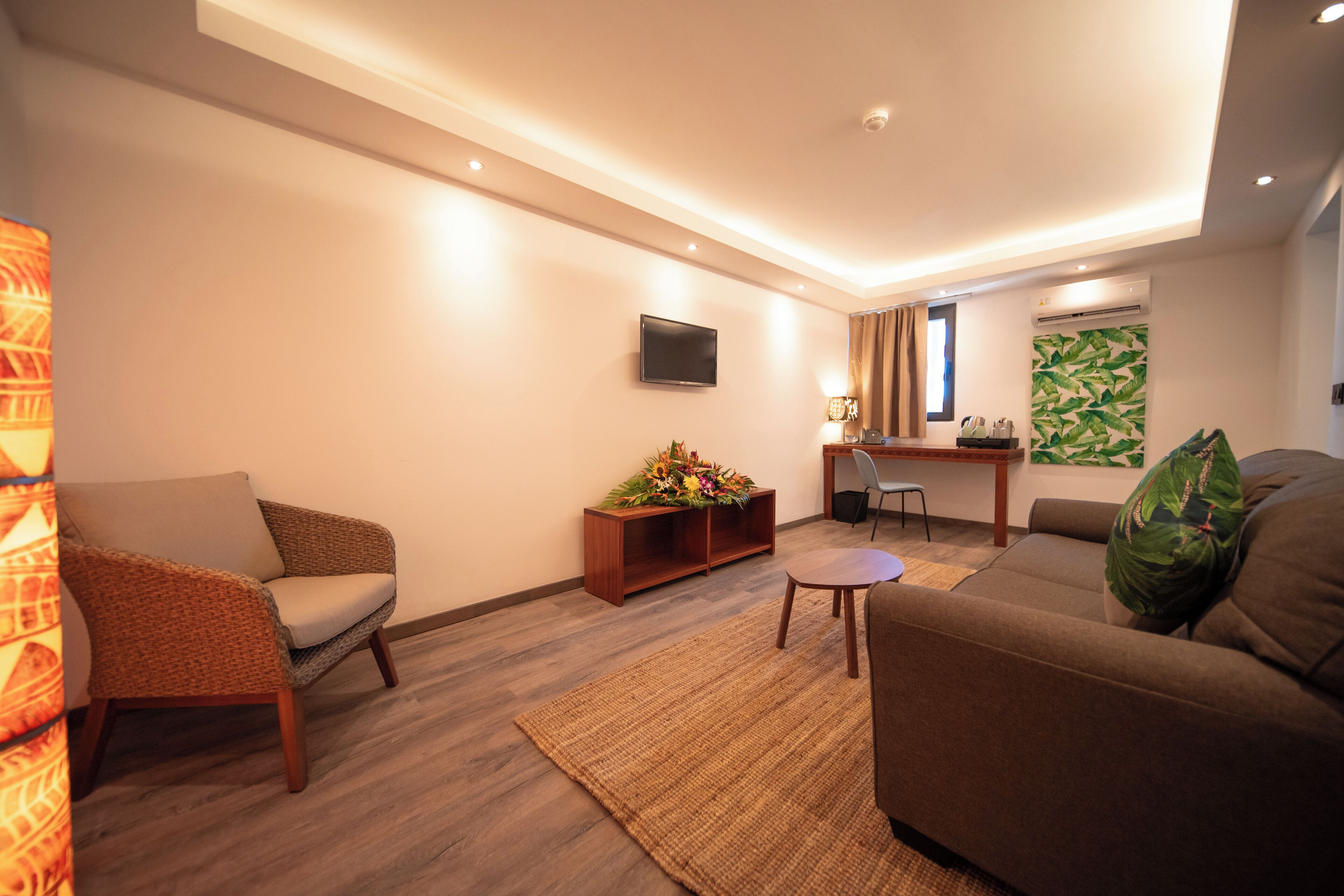 Una sala moderna con un sofá, un sillón y una mesita con una planta decorativa.