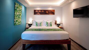 A modern hotel room with a large bed, a flat-screen TV, and a ceiling light fixture.