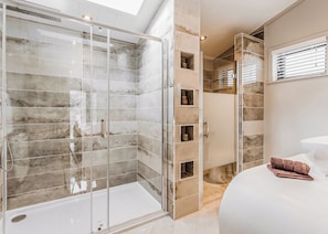 A modern bathroom with a glass-enclosed shower, a white bathtub, and a vanity with a sink. - 2 bedroom accommodation in Bridgnorth (Bridgnorth)
