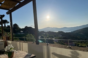 Una terrazza con vista su montagne lontane e cielo sereno.