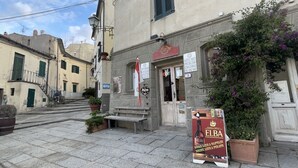 Une vue de rue avec un bâtiment sur lequel on peut voir une enseigne indiquant « ELBA » et un banc à l’extérieur.