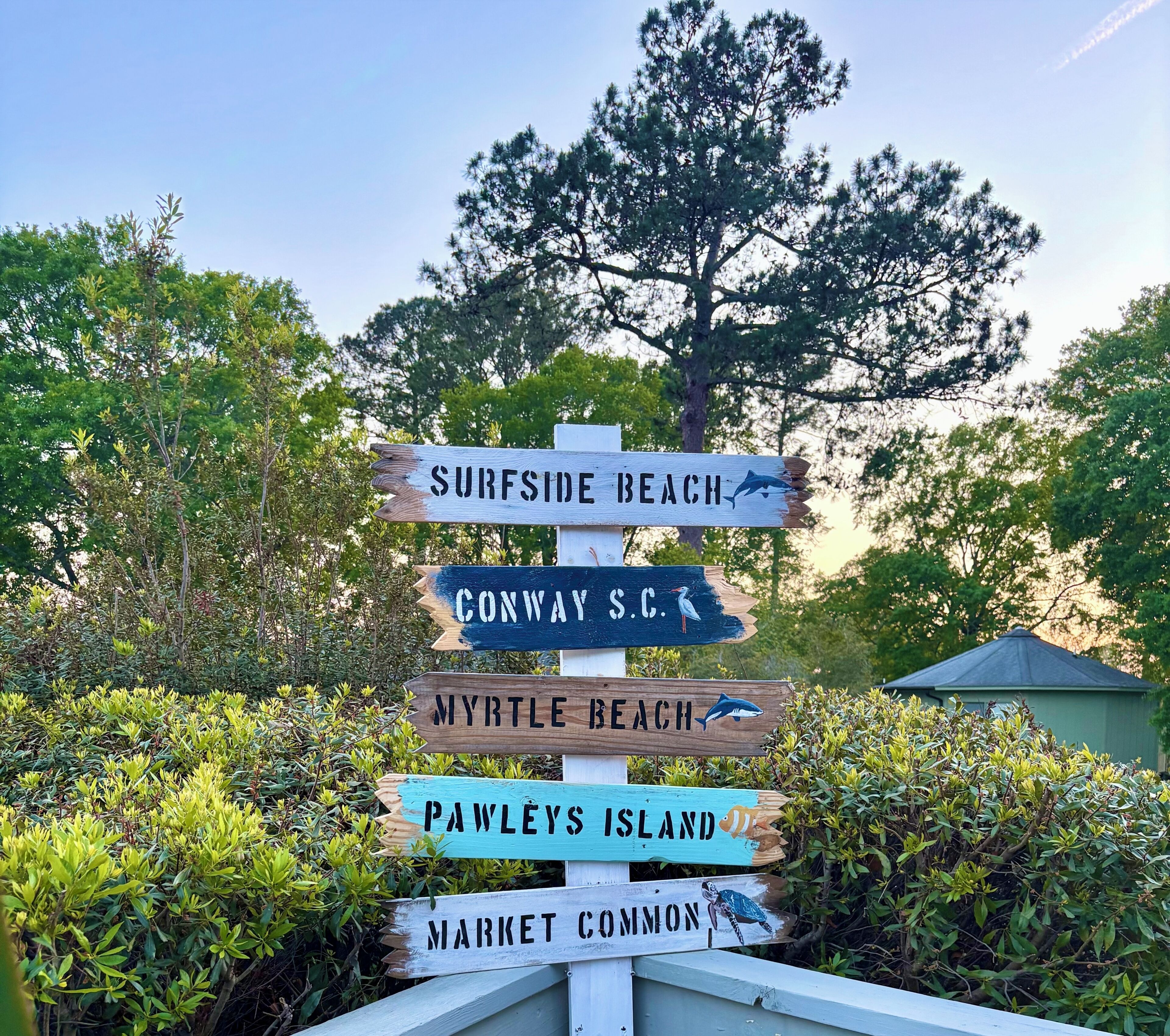 A wooden signpost with directions to various beaches and locations.