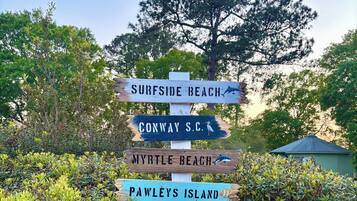 A wooden signpost with directions to various beaches and locations.