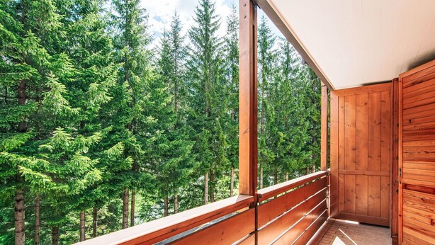 A balcony with a wooden railing overlooking a forest. - Beautiful apartment for 4 guests with WIFI, TV and balcony (Canazei)