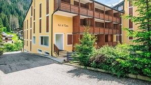A multi-story building with a yellow facade, wooden balconies, and a sign reading "Val di Fassa". - Beautiful apartment for 4 guests with WIFI, TV and balcony (Canazei)