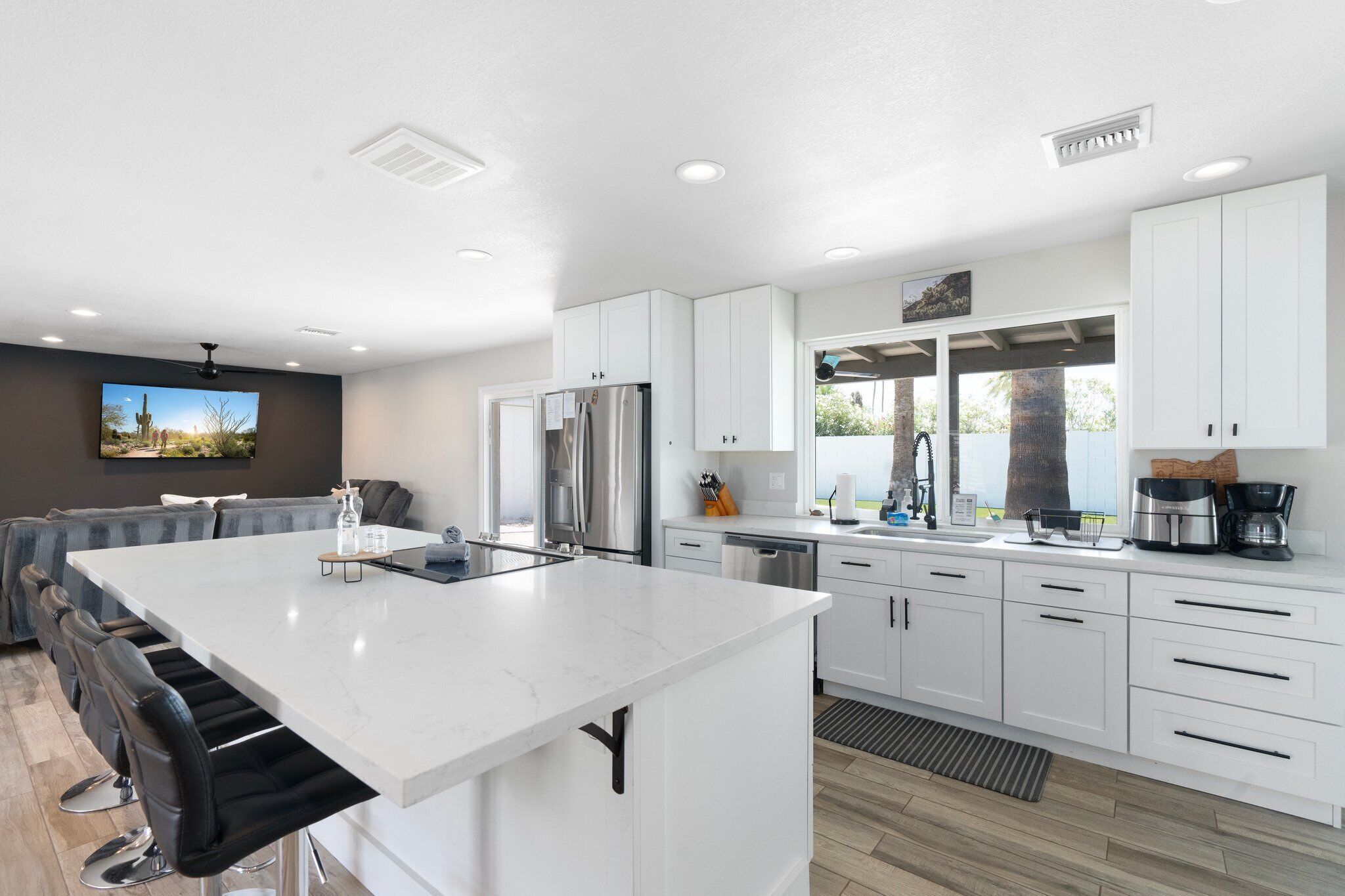Una cocina moderna con armarios blancos, electrodomésticos de acero inoxidable y una isla grande.