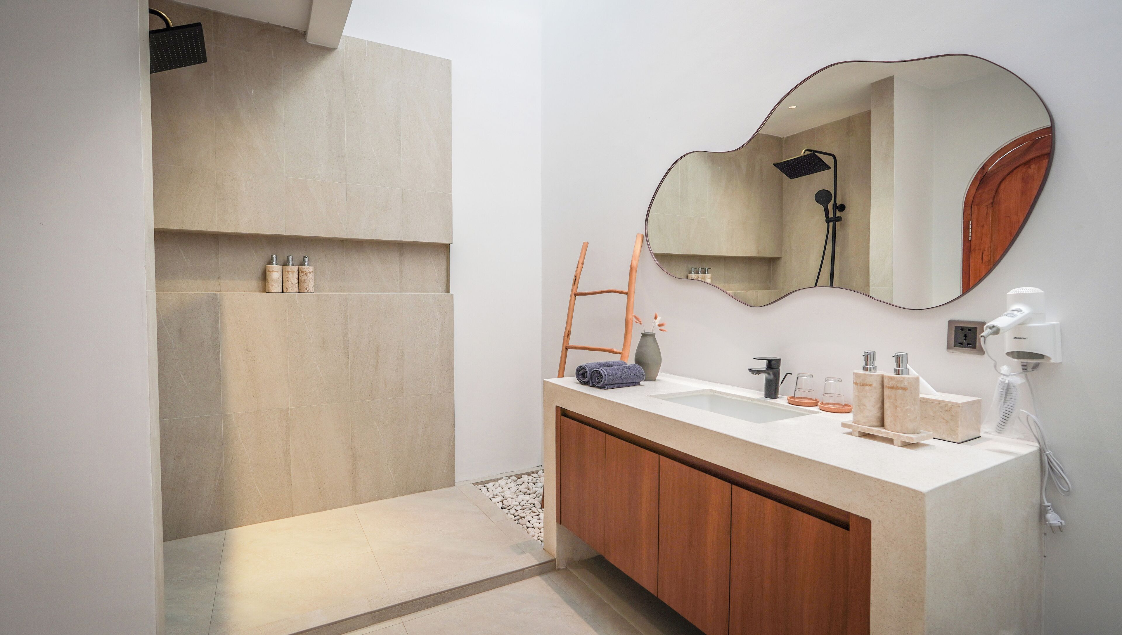 A modern bathroom with a shower, vanity, and a large mirror.