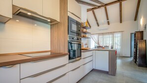 Een moderne keuken met houten balken, inbouwapparatuur en een groot kookeiland.