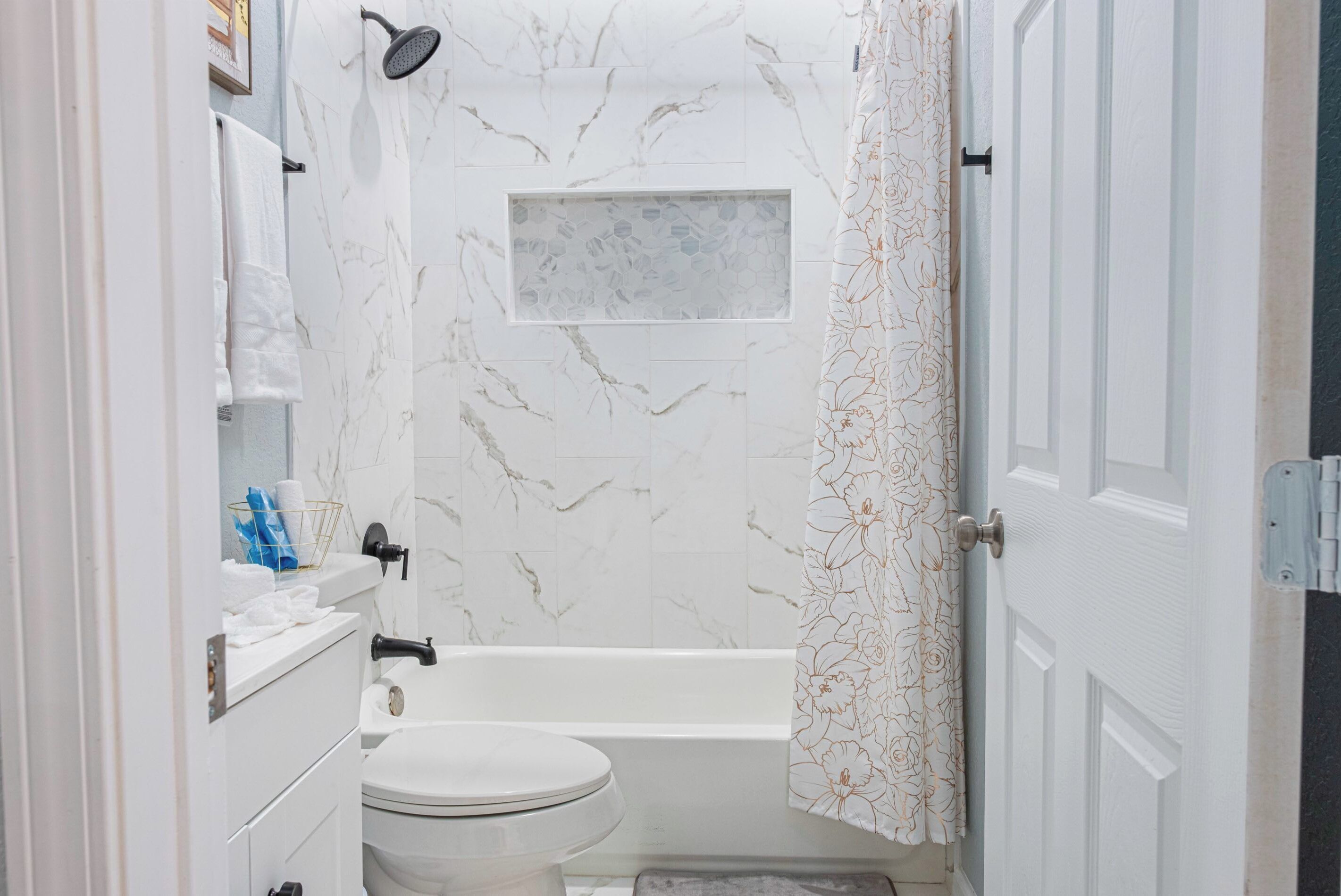 A bathroom with a toilet, sink, and bathtub.