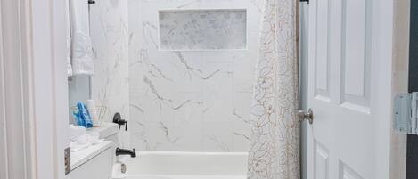 A bathroom with a toilet, sink, and bathtub.