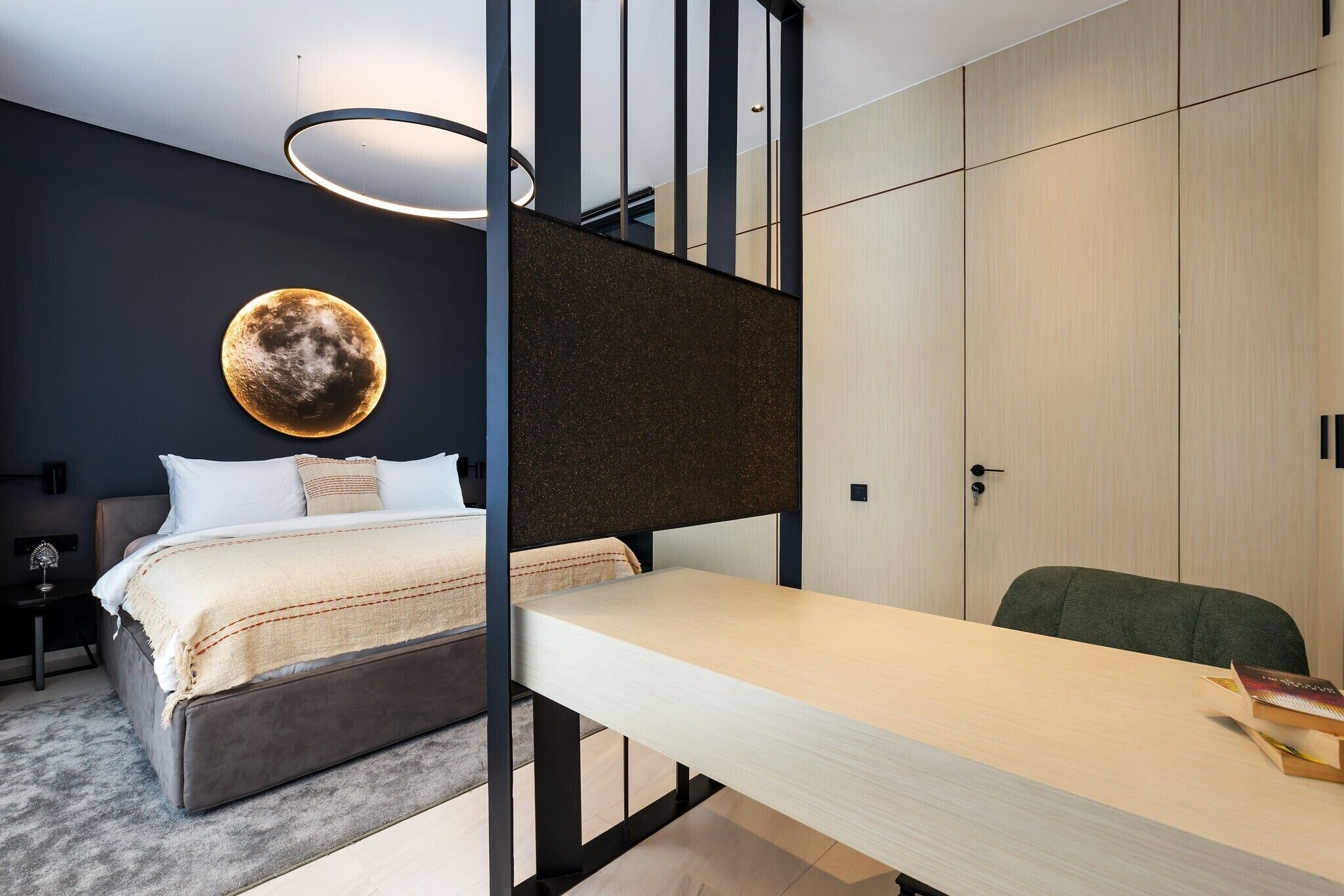 Een moderne slaapkamer met een bed, bureau en kledingkast.