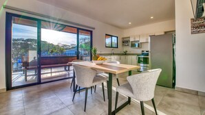 Una cocina moderna con comedor, ventanas amplias y vistas al exterior.