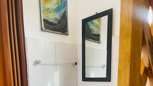 A bathroom with a white sink, a mirror, a towel rack, and a toilet paper holder. - Family room in a beachfront cabin - Barú (Cartagena)