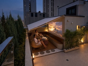 A rooftop terrace with a seating area, a mountain view mural, and a small garden. - Jamsil Orosie Hotel (Seoul)