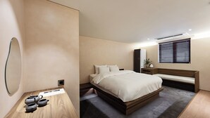Une chambre à coucher moderne avec un lit, une table de chevet et un grand miroir.