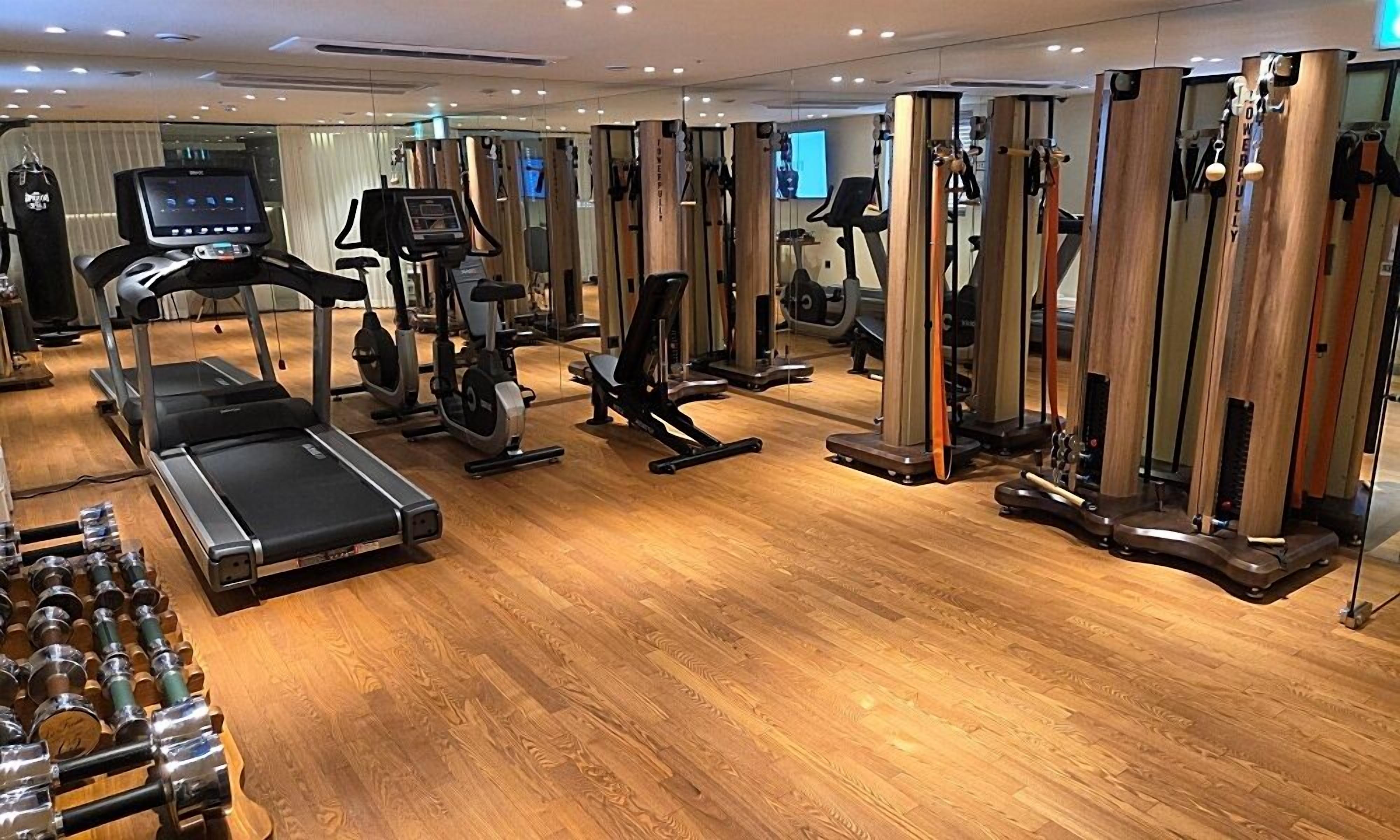 A gym with treadmills, elliptical machines, and weightlifting equipment.