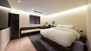 A modern bedroom with a bed, bedside table, and a built-in TV.
