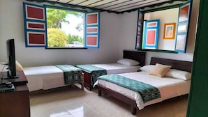 Una habitación con dos camas, un escritorio y un televisor.