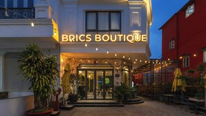 A boutique hotel with a well-lit entrance, outdoor seating, and potted plants. - BRICS Boutique Dalat (Lam Vien - Da Lat)