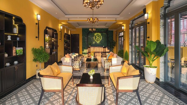 A hotel lobby with a central seating area, a chandelier, and a large potted plant. - BRICS Boutique Dalat (Lam Vien - Da Lat)