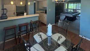 A modern kitchen with a dining area, a pool table, and a chandelier. - Golfer’s Dreamhouse (Pinehurst)