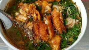 Eine Schüssel Suppe mit Nudeln, Gemüse und Fleisch.