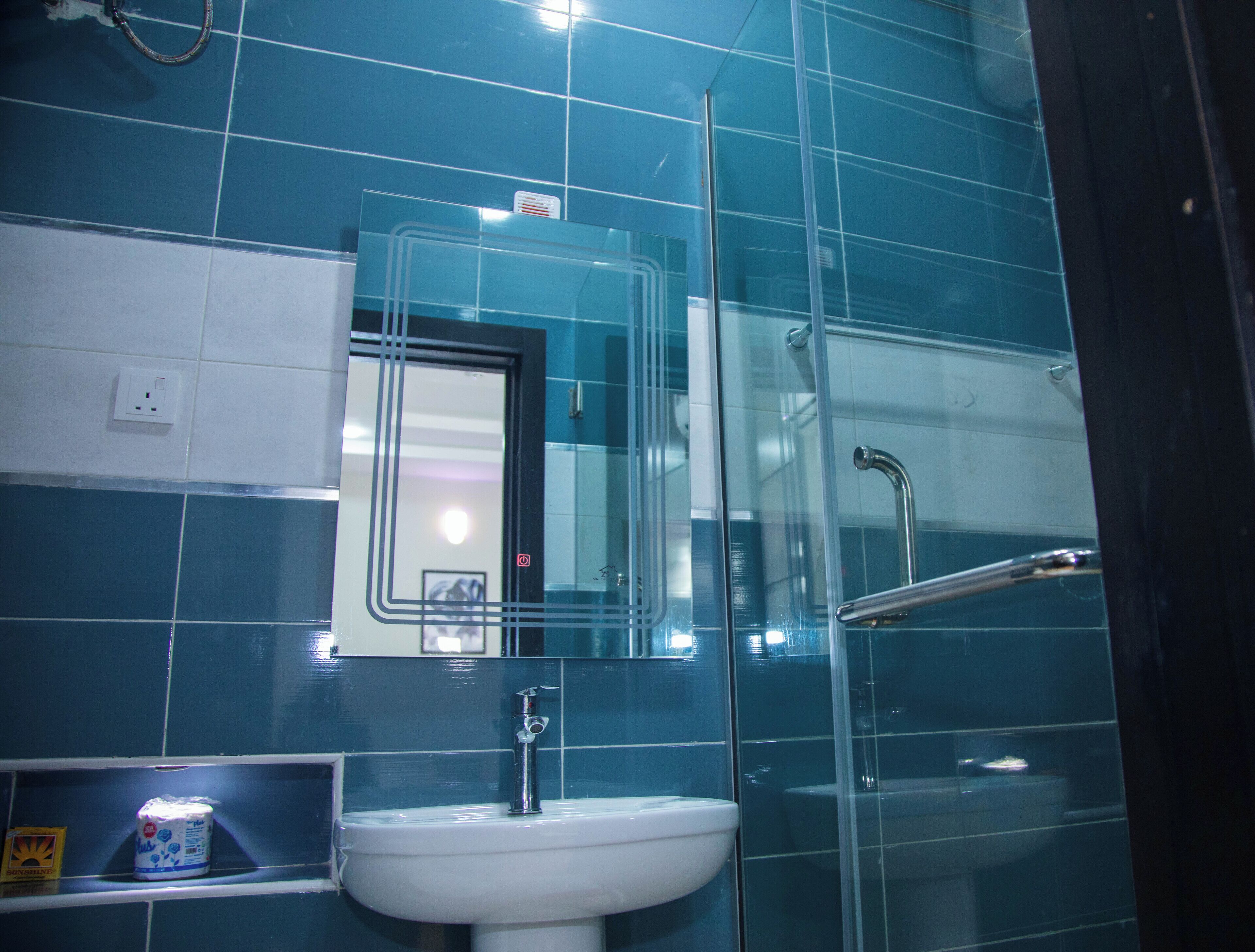 Ein Badezimmer mit Waschbecken, Spiegel und Duschkabine.