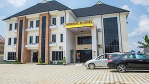 A hotel with a modern design, featuring a prominent entrance, a covered area, and a parking lot.