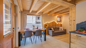 A cozy interior with a wooden dining area, a sofa, and a kitchen counter. - Casa Fiorita, Livigno, Italy (Livigno)