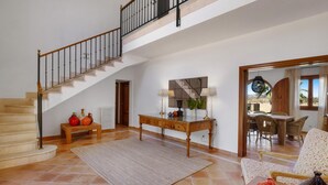 Un amplio espacio habitable con una escalera, un comedor con vistas y una zona de estar acogedora.