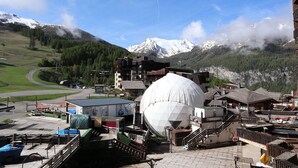 Un paese di montagna con una grande struttura a cupola bianca, edifici in legno e una pista da sci.