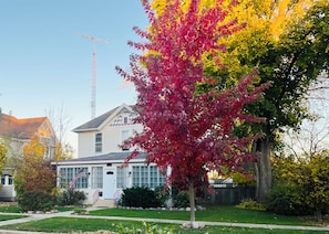 A residential house with a front yard, a mailbox, and a flag.